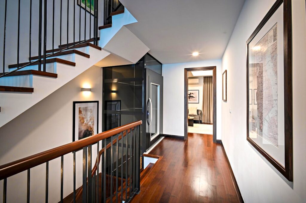 Sleek and modern corridor with staircase featuring wooden floors and stylish railing.