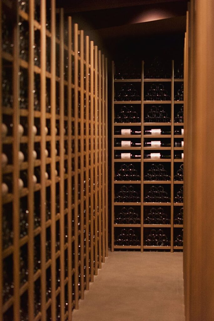 Discover an elegant wine cellar display with rows of wine bottles in Pauillac, France.
